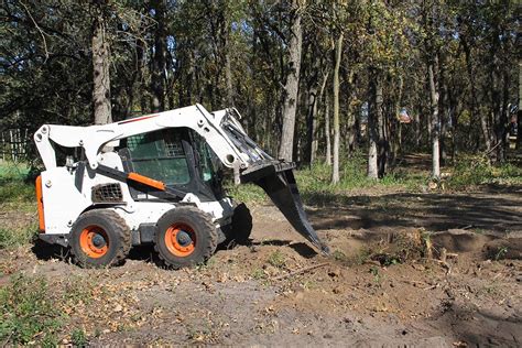 cutting ditch with skid steer|skid steer bucket digging.